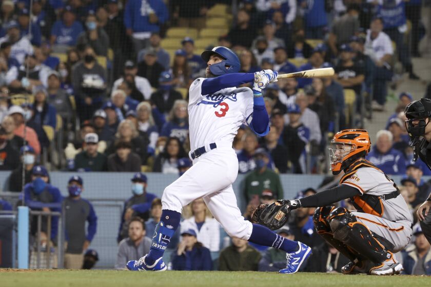 Los Angeles, CA - October 12: Los Angeles Dodgers' Chris Taylor follows through on a swing for a sacrifice fly ball to score Gavin Lux during the second inning in game four of the 2021 National League Division Series against the San Francisco Giants at Dodger Stadium on Tuesday, Oct. 12, 2021 in Los Angeles, CA. (Robert Gauthier / Los Angeles Times)
