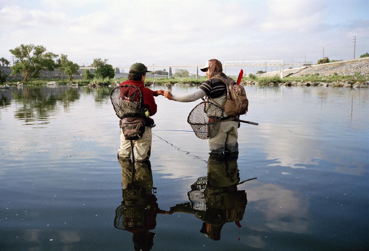 Lauren Mollica, left, and Lino Jubilado fishing early in the morning in Long Beach.