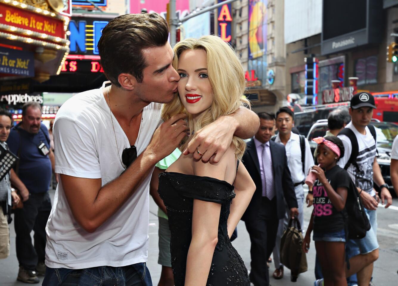 Model Luke Stockman poses with Madame Tussauds New York first-ever wax figure of actress Scarlett Johansson in New York City.