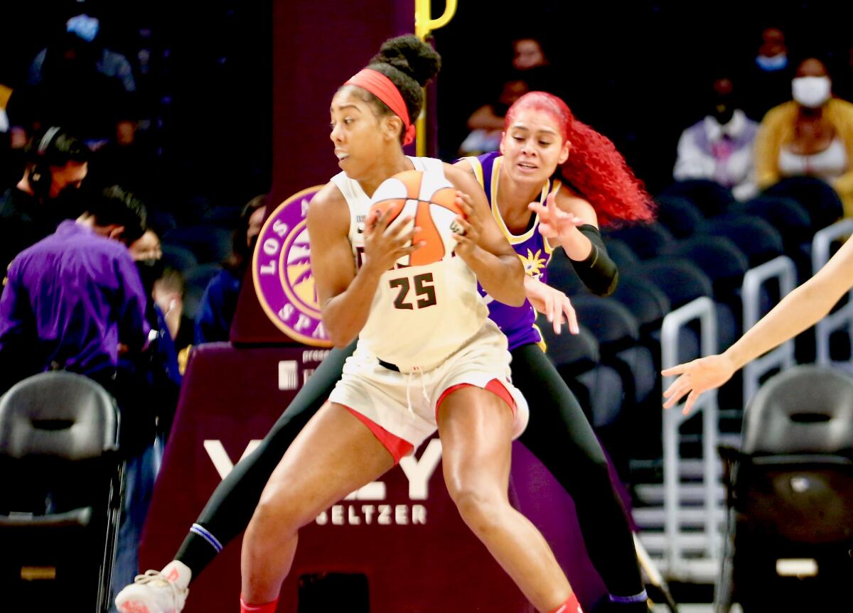 Sparks' Amanda Zahui B reaches to try to steal the ball from Atlanta Dream forward Monique Billings.