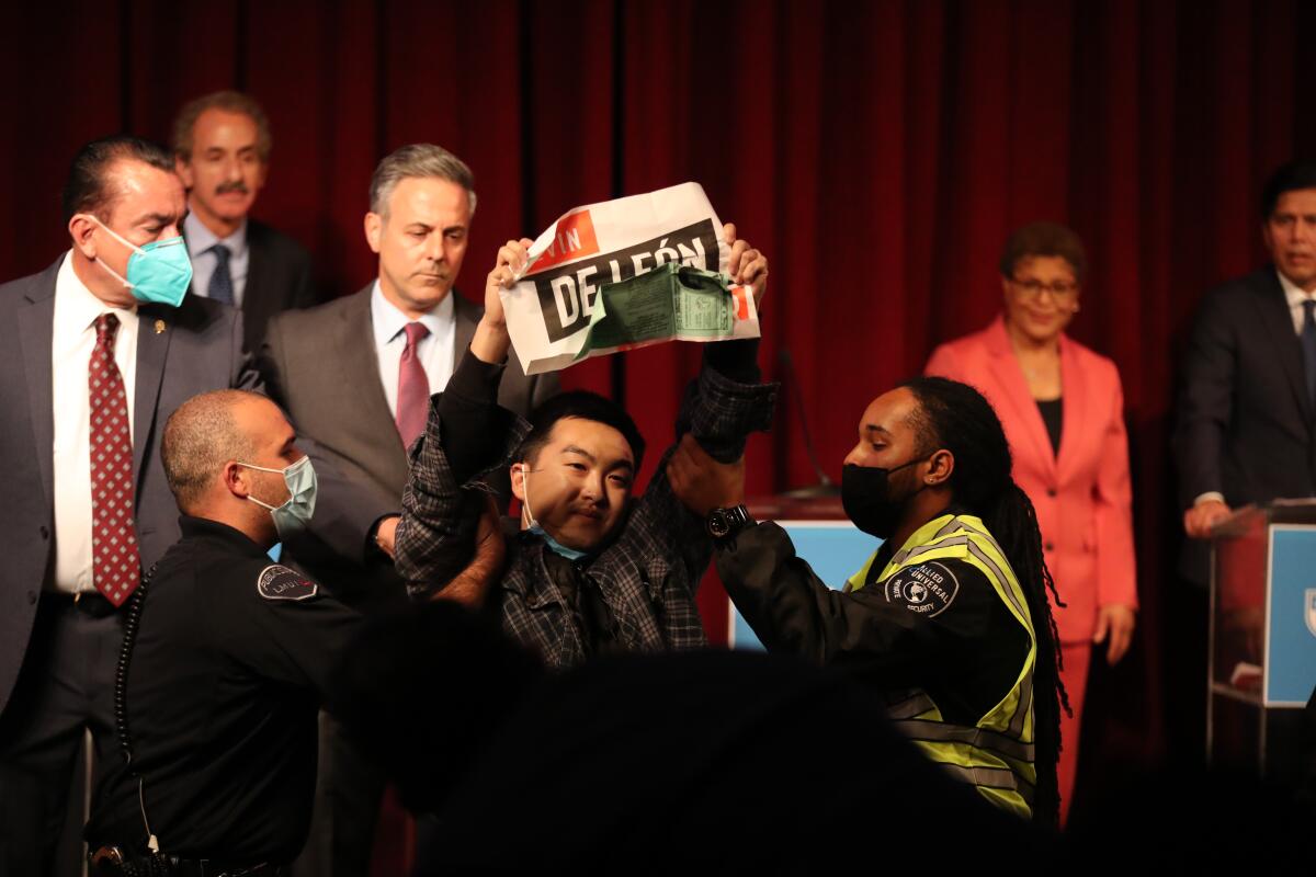 A protester is removed from Tuesday night's Los Angeles mayoral debate at Loyola Marymount University.