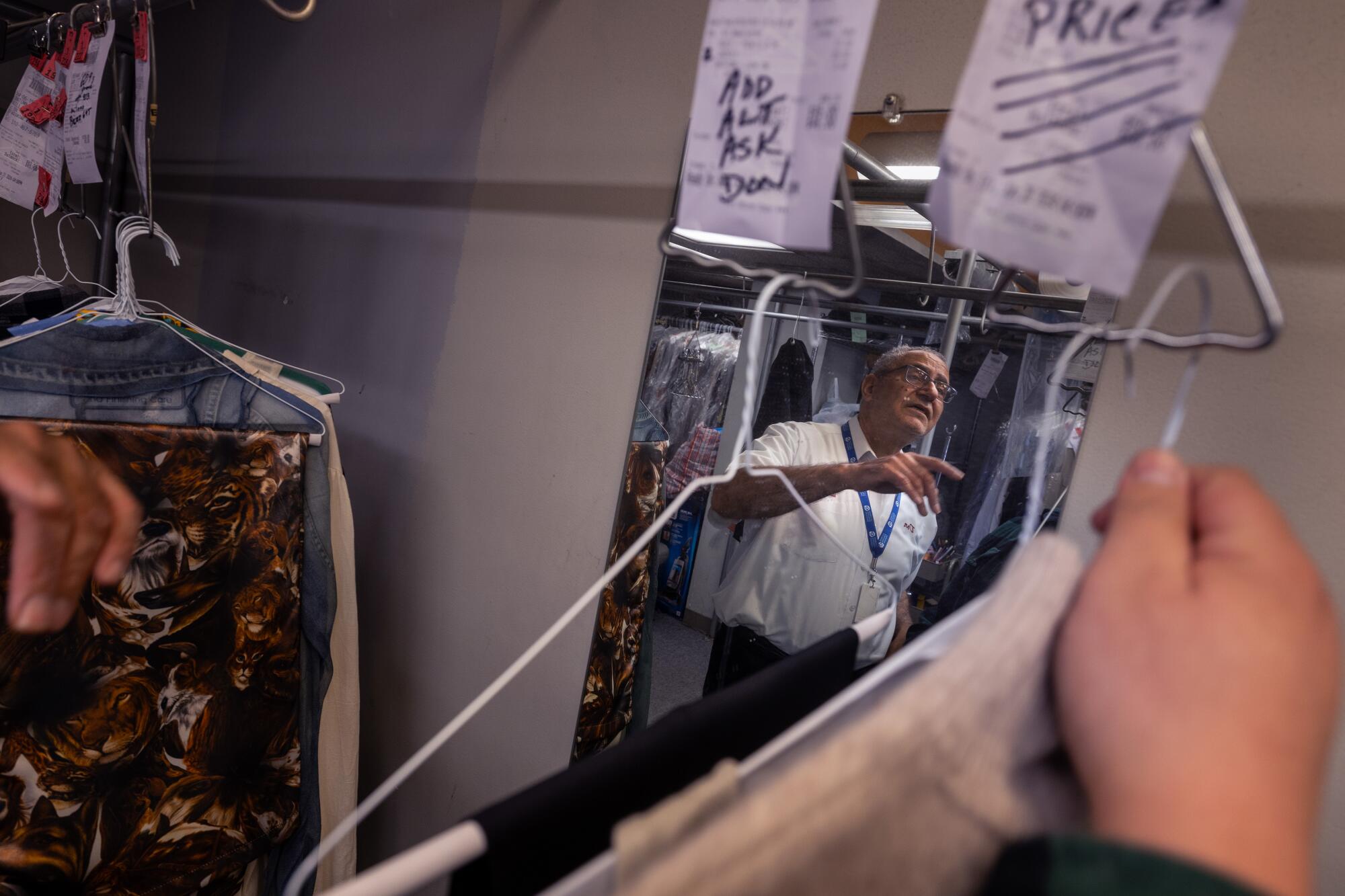 Don Kohan helps employee Santiago Lopez sort through garments.