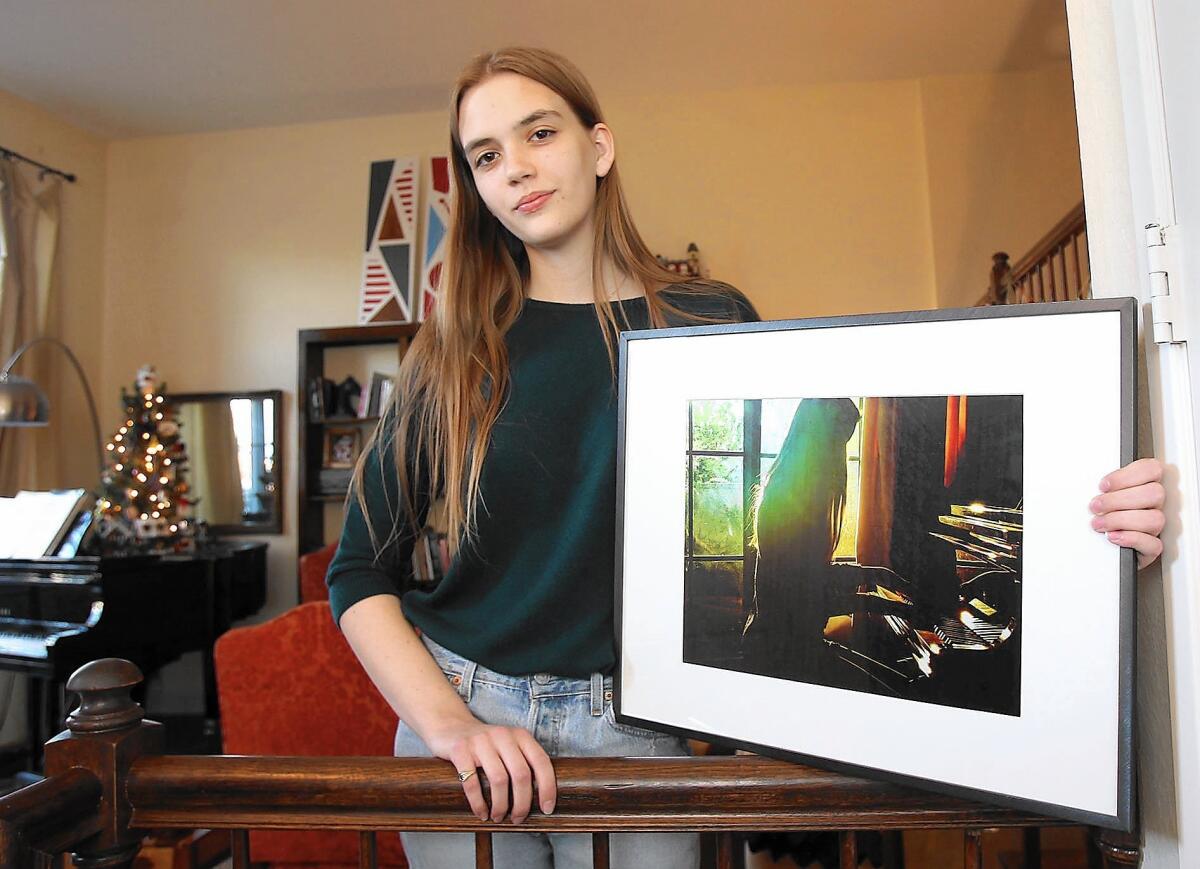 Irvine student Lily McBeath holds an example of her photography. She is one of 10 students nationwide to have her artwork displayed at the Vice President's residence this month.