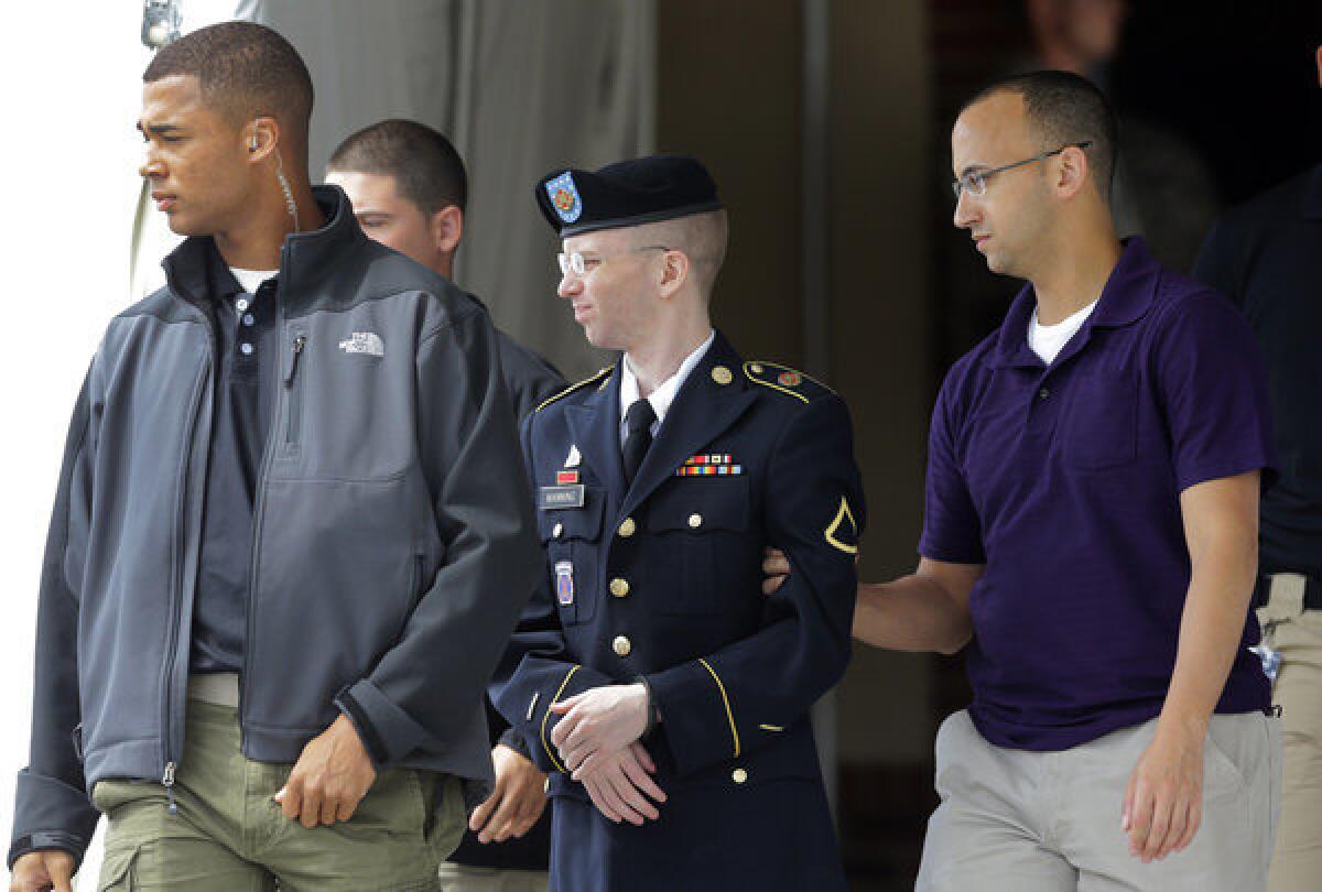 Army Pfc. Bradley Manning, center, is escorted to a security vehicle outside a courthouse in Fort Meade, Md.