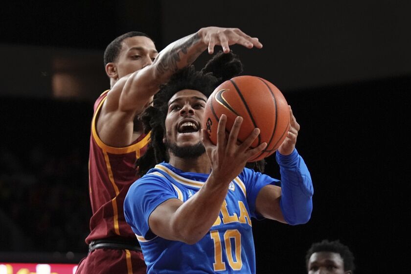 UCLA guard Tyger Campbell, right, shoots as Southern California forward Kobe Johnson defends during the first half of an NCAA college basketball game Thursday, Jan. 26, 2023, in Los Angeles. (AP Photo/Mark J. Terrill)