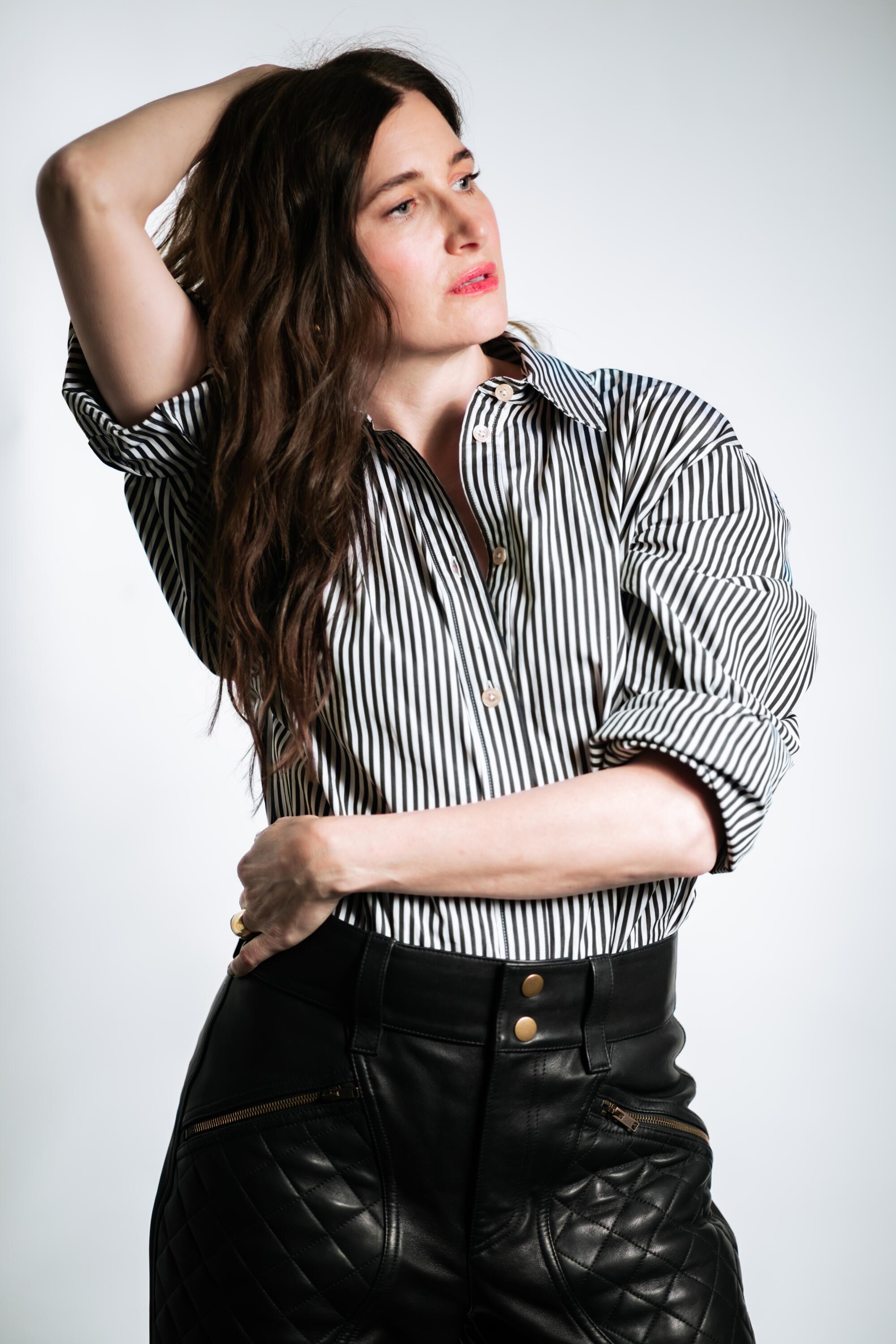 Woman standing with arms around her body.