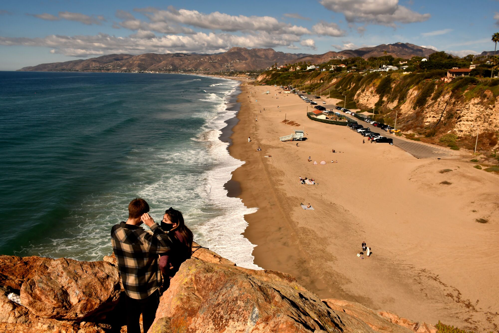 People on a bluff overlooking Point Dume State Beach in Malibu.