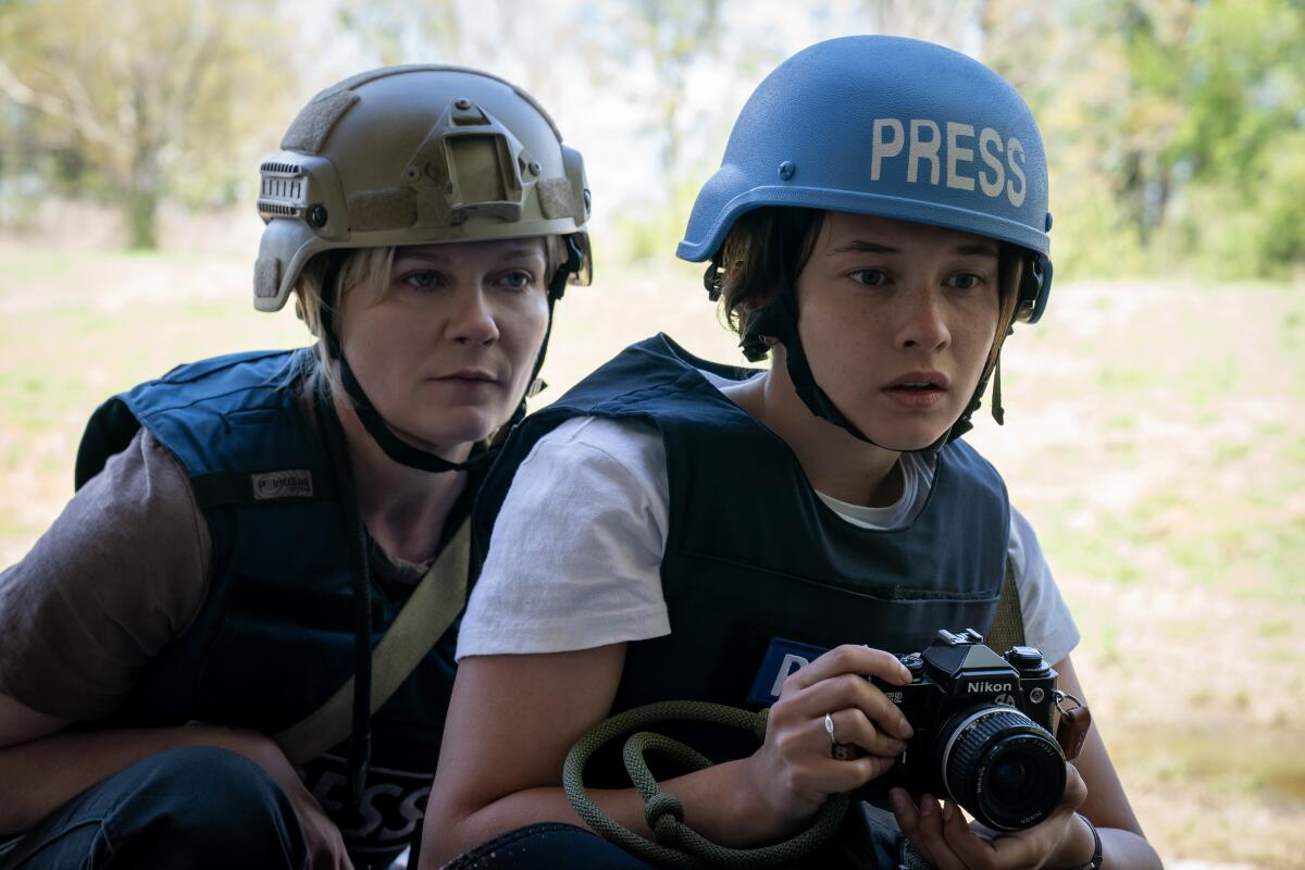 Two helmeted photojournalists take in the action.
