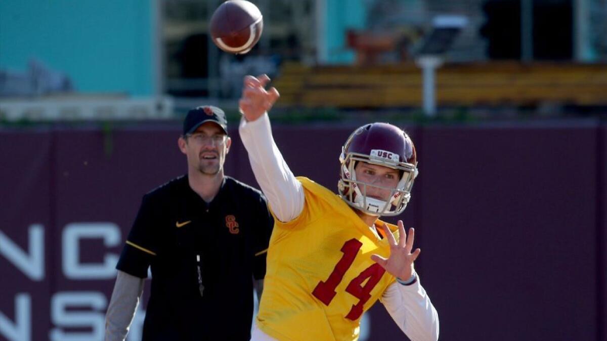 USC quarterback Sam Darnold runs through drills on the first day of spring practice at Howard Jones Field while quarterbacks coach Tyson Helton looks on.