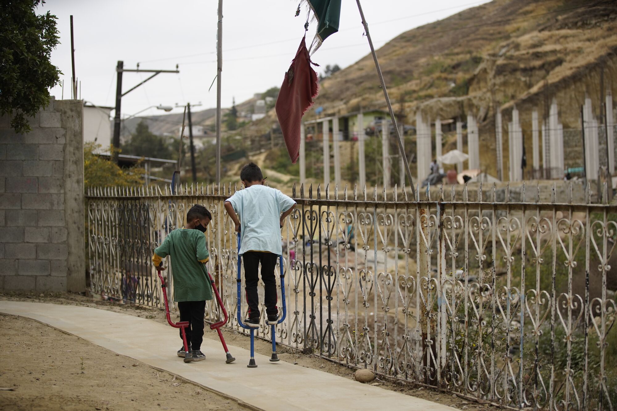 Dos niños juegan con zancos fuera de la escuela