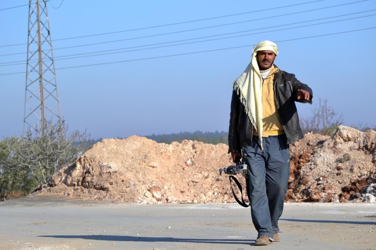 A rebel fighter gestures as he walks towards a checkpoint close to Jabal al-Zawiyaa in Idlib province. The United Nations and the United States hope to launch a peace conference for Syria on Jan. 22.