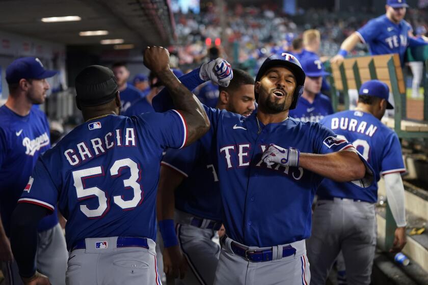 Texas Rangers' Marcus Semien, right, celebrates his home run against the Los Angeles Angels with Adolis Garcia during the ninth inning of a baseball game Wednesday, Sept. 27, 2023, in Anaheim, Calif. (AP Photo/Jae C. Hong)