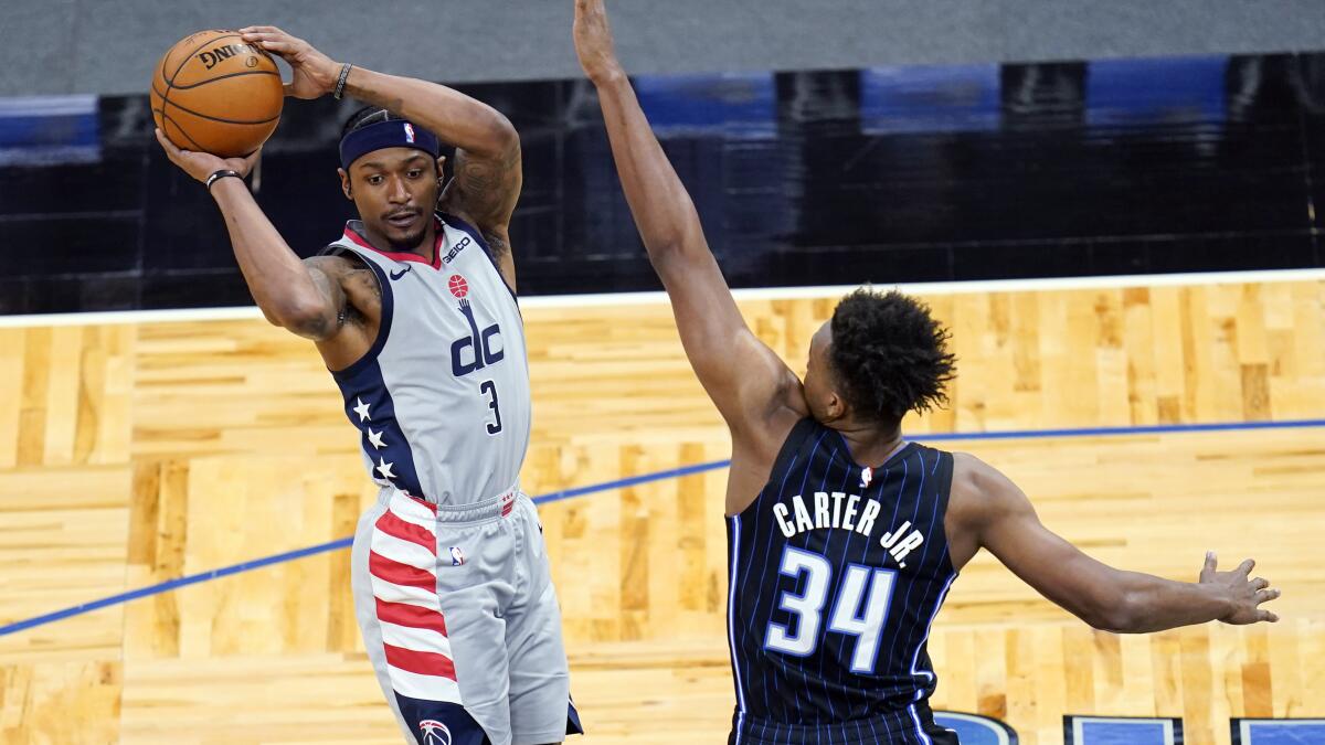 Washington Wizards guard Bradley Beal (3) passes the ball as he is defended by Orlando Magic center Wendell Carter Jr. (34) during the first half of an NBA basketball game Wednesday, April 7, 2021, in Orlando, Fla. (AP Photo/John Raoux)
