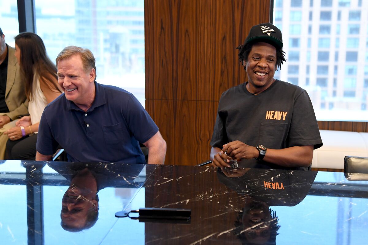 Two men, smiling, sit at a conference table