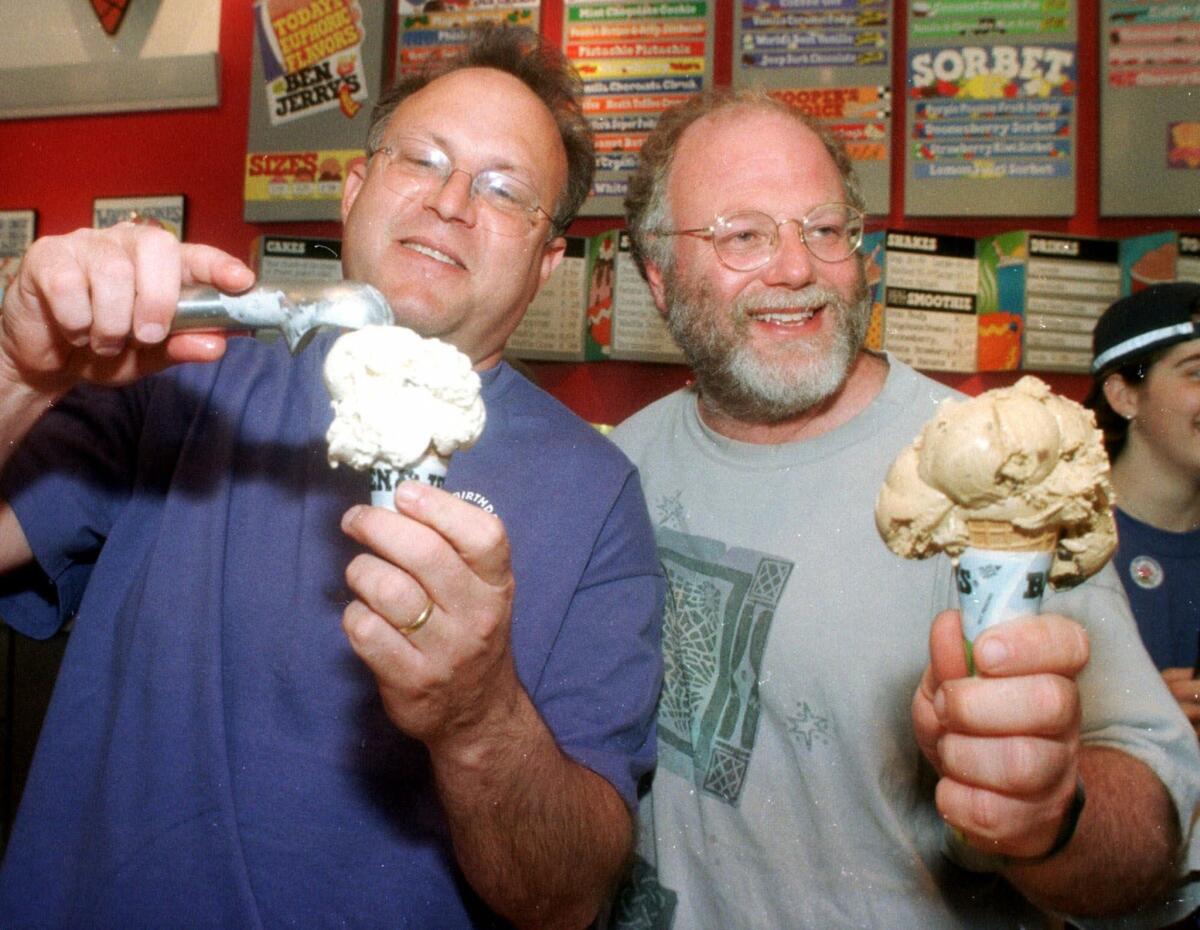 Jerry Greenfield, left, and Ben Cohen, founders of Ben & Jerry's, scoop ice cream cones during their 20th anniversary party at a shop in Burlington, Vt.