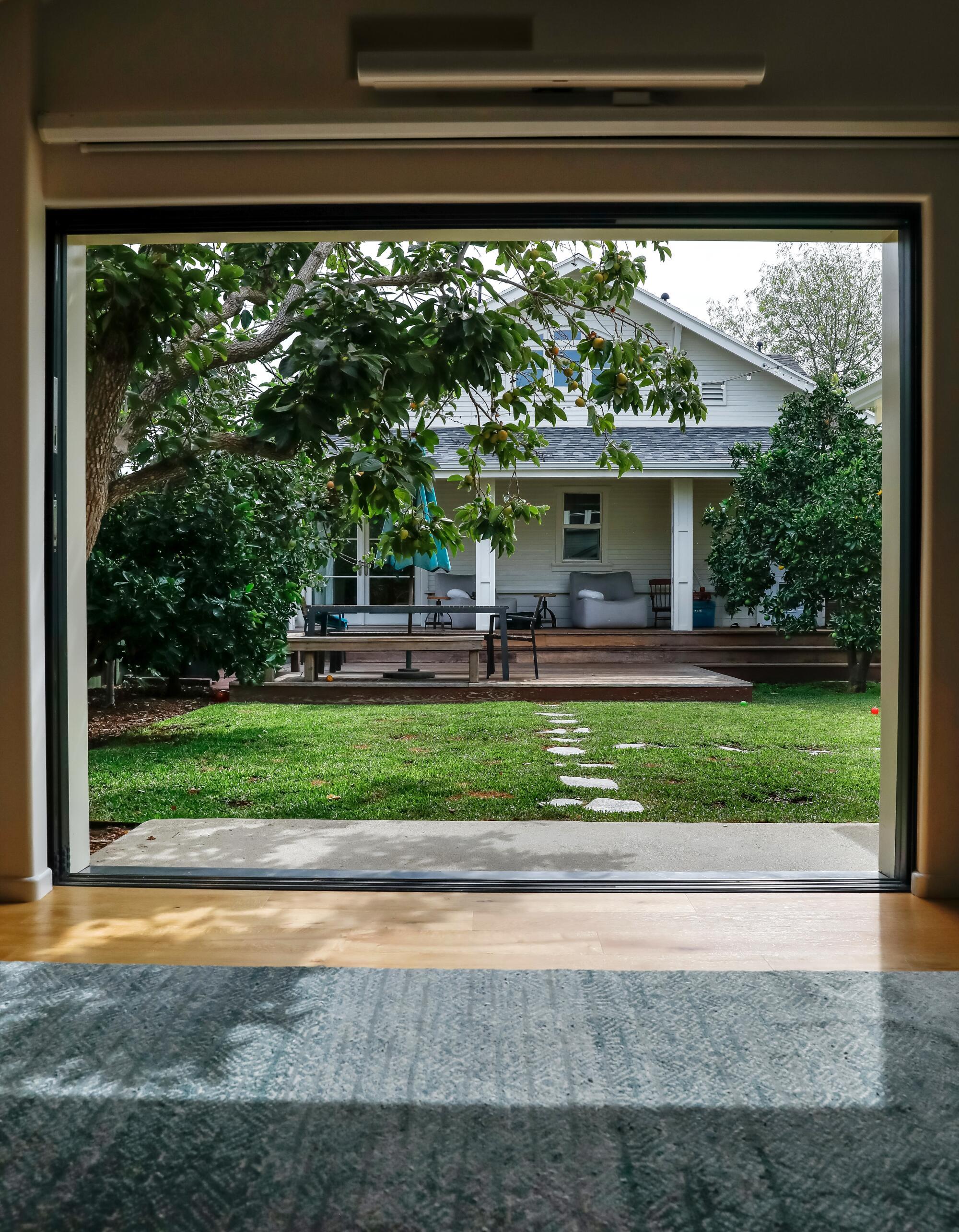 A view of a 1922 Craftsman house's back porch from the inside of an ADU. 