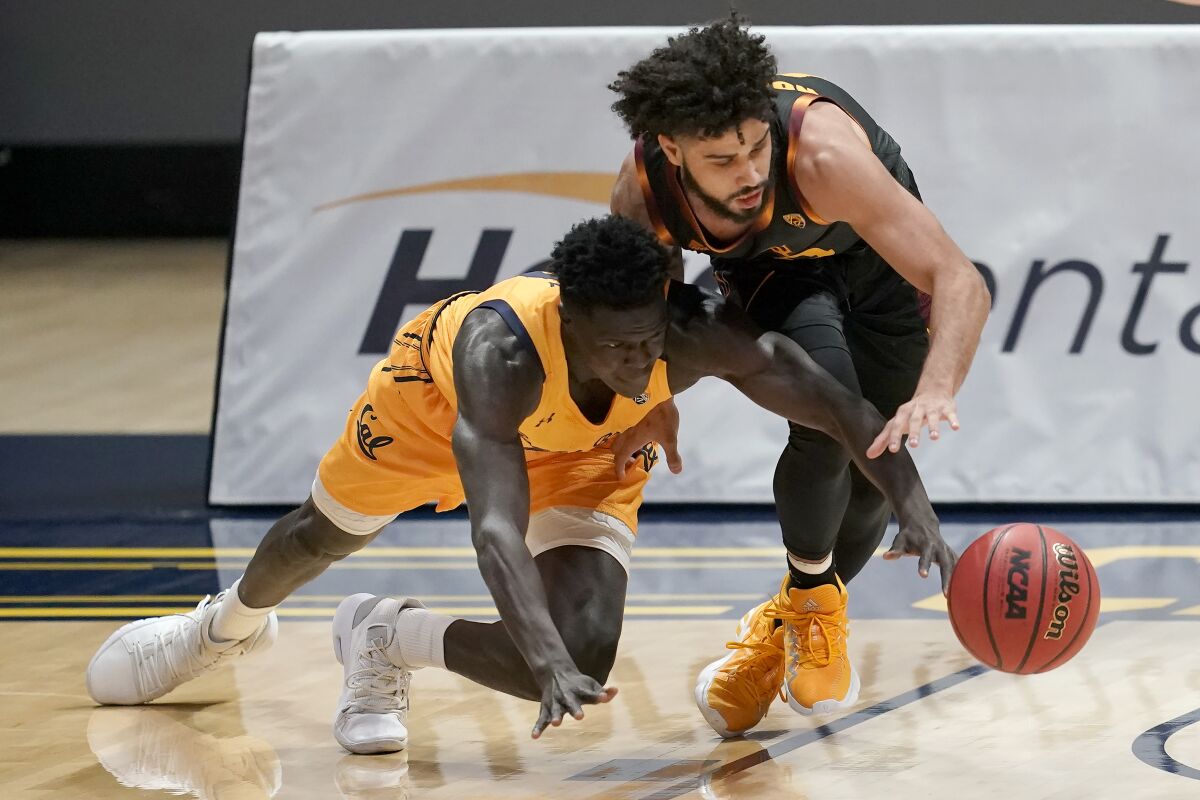 California forward Kuany Kuany reaches for the ball under Arizona State guard Holland Woods.