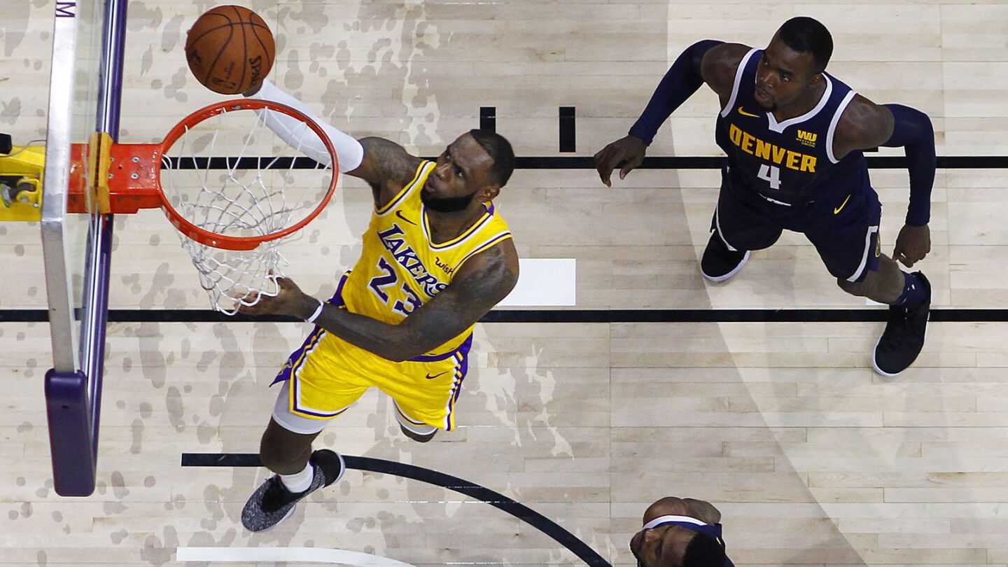 Los Angeles Lakers LeBron James goes up for a shot between Denver Nuggets Paul Millsap, top, and Will Barton during a preseason game in San Diego on Sunday, September 30, 2018. (Photo by K.C. Alfred/San Diego Union-Tribune)