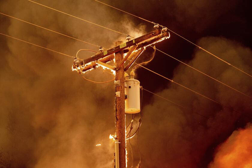 Fire burns along a power pole as the Sugar Fire, part of the Beckwourth Complex Fire, tears through central Doyle, Calif., on Saturday, July 10, 2021. (AP Photo/Noah Berger)