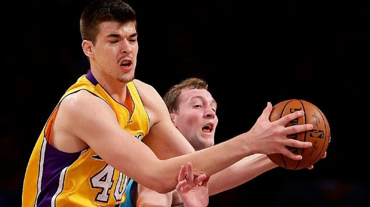 Lakers center Ivica Zubac, pulling down a rebound over Hornets center Cody Zeller during a game on Feb. 28, will be under the watchful eye of management as he works on his game this summer.