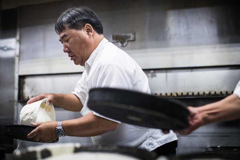 LOS ANGELES, CA - June 13, 2018 Youlen Chan pours cake batter at Phoenix Bakery in Chinatown, a family-owned establishment for over 80 years, on June 13, 2018. Youlen explains that as a teen, working in the bakery was "a prerequisite of being part of the family." He went on to college and baking school before taking over full-time at the bakery, where his siblings and children help out on the weekends. (Gabriel S. Scarlett / Los Angeles Times)