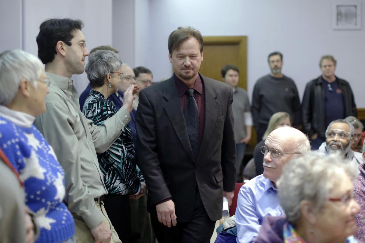 A man places a hand on the shoulder of the Rev. Frank Schaefer, a United Methodist clergyman suspended for officiating at his son's same-sex wedding, as he enters a news conference Monday at the Arch Street United Methodist Church in Philadelphia. Schaefer plans to defy a church order to surrender his credentials for performing a same-sex wedding.