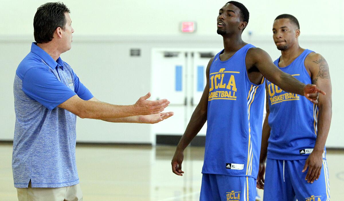 UCLA Coach Steve Alford directs guards Isaac Hamilton, center, and Norman Powell during media day last week.