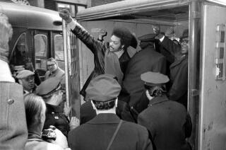 Jackson raises a clenched fist from a police van.