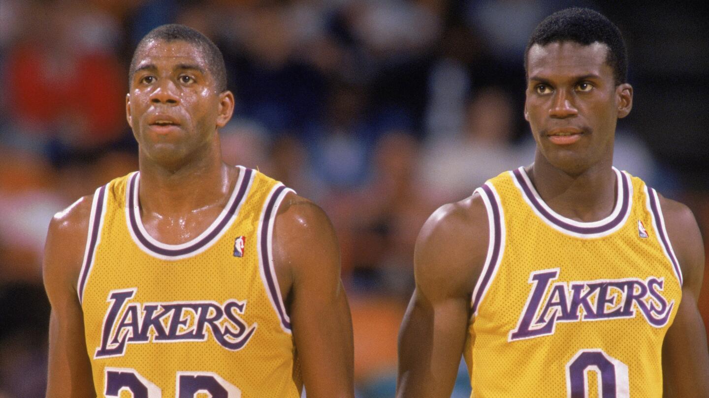 Lakers teammate Magic Johnson, left, and Orlando Woolridge look on during a game at the Forum in 1988.