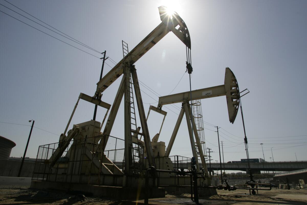 A pair of drilling rigs pump out oil in Long Beach in 2008.