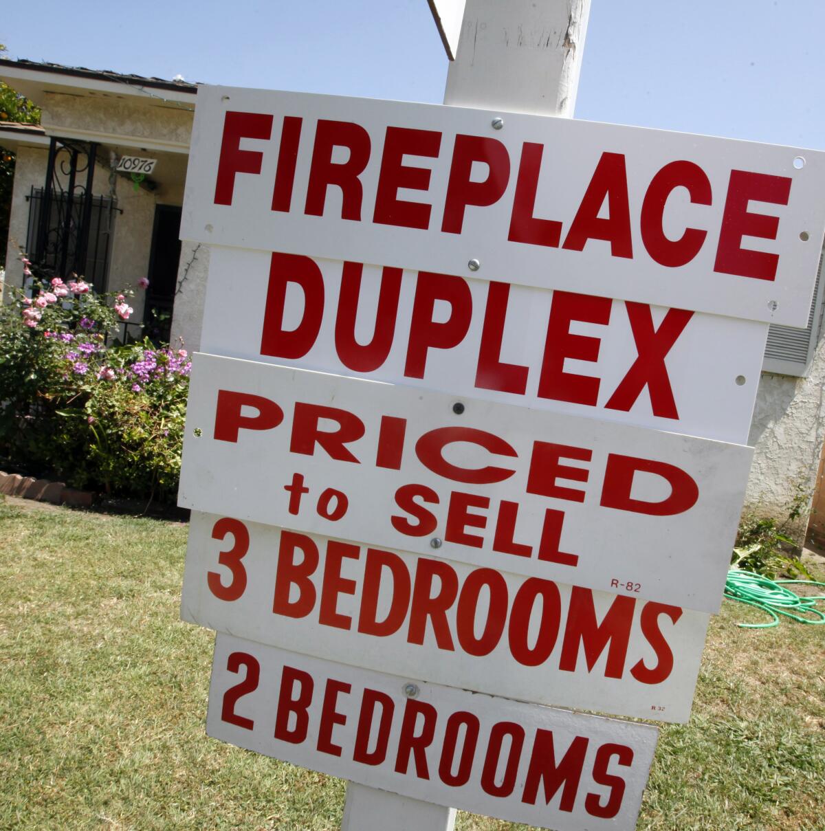 A yard sign advertises a duplex for sale in Los Angeles. 