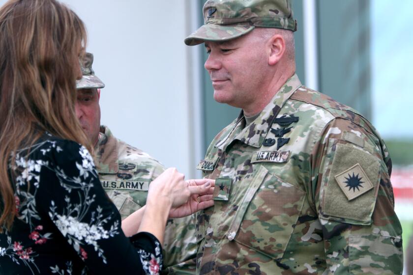 With U.S. Army Major General David S. Baldwin looking on at center, Brigadier General Nick Ducich has his promotional star placed on his jacket by his wife Tia Ducich during ceremony at the 40th Infantry Division Headquarters in Los Alamitos on Saturday, Jan. 11, 2020.