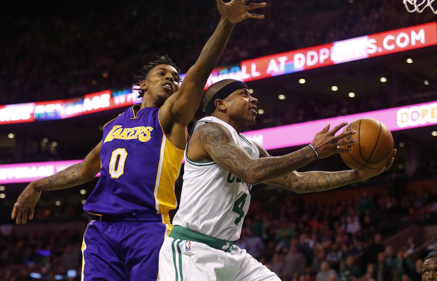Celtics guard Isaiah Thomas drives past Lakers guard Nick Young for a layup during the first half.