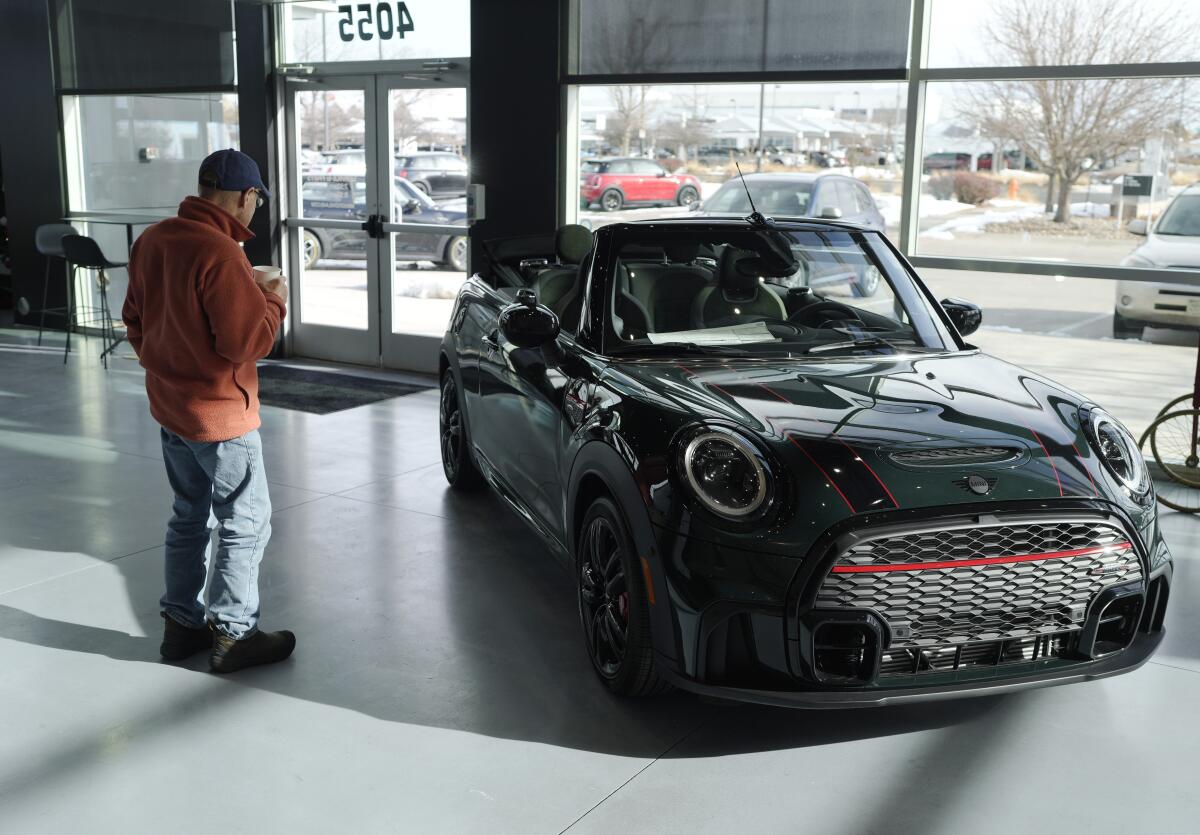  A man looks at a 2024 Mini Cooper car