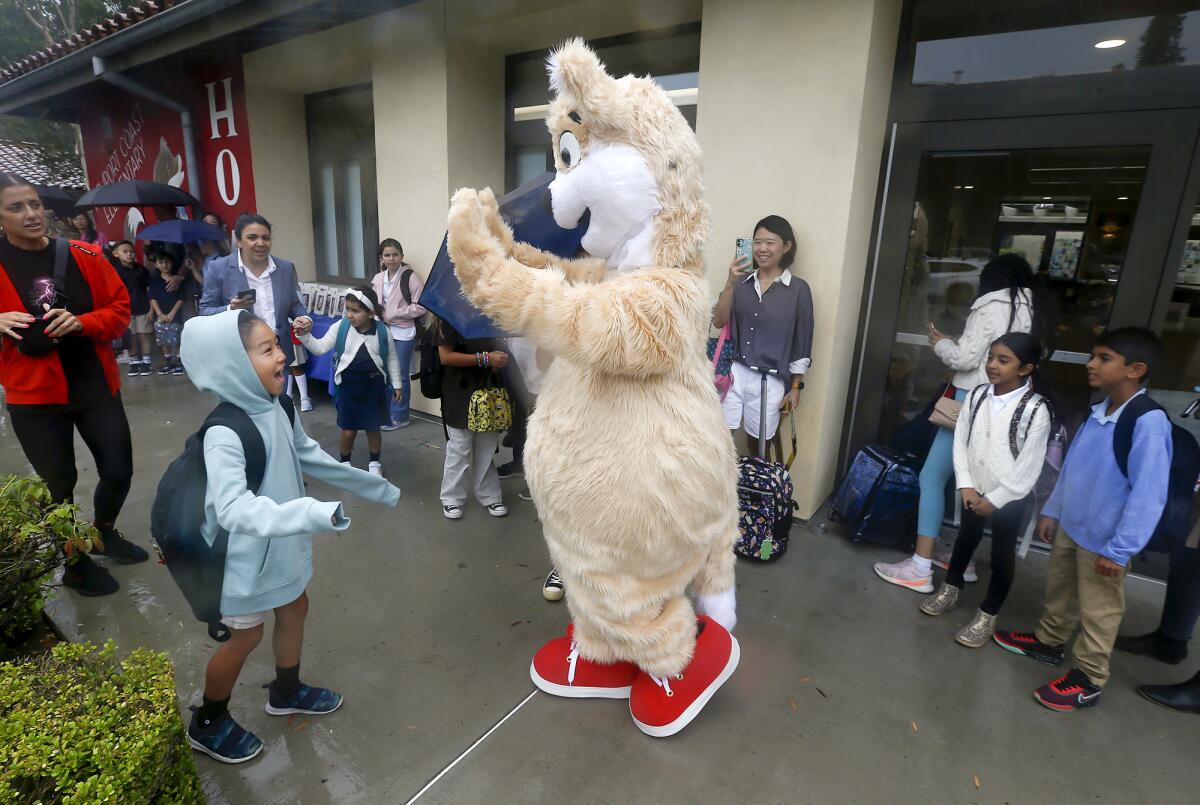 Charlie the Coyote welcomes kids at Newport Coast Elementary on Monday.