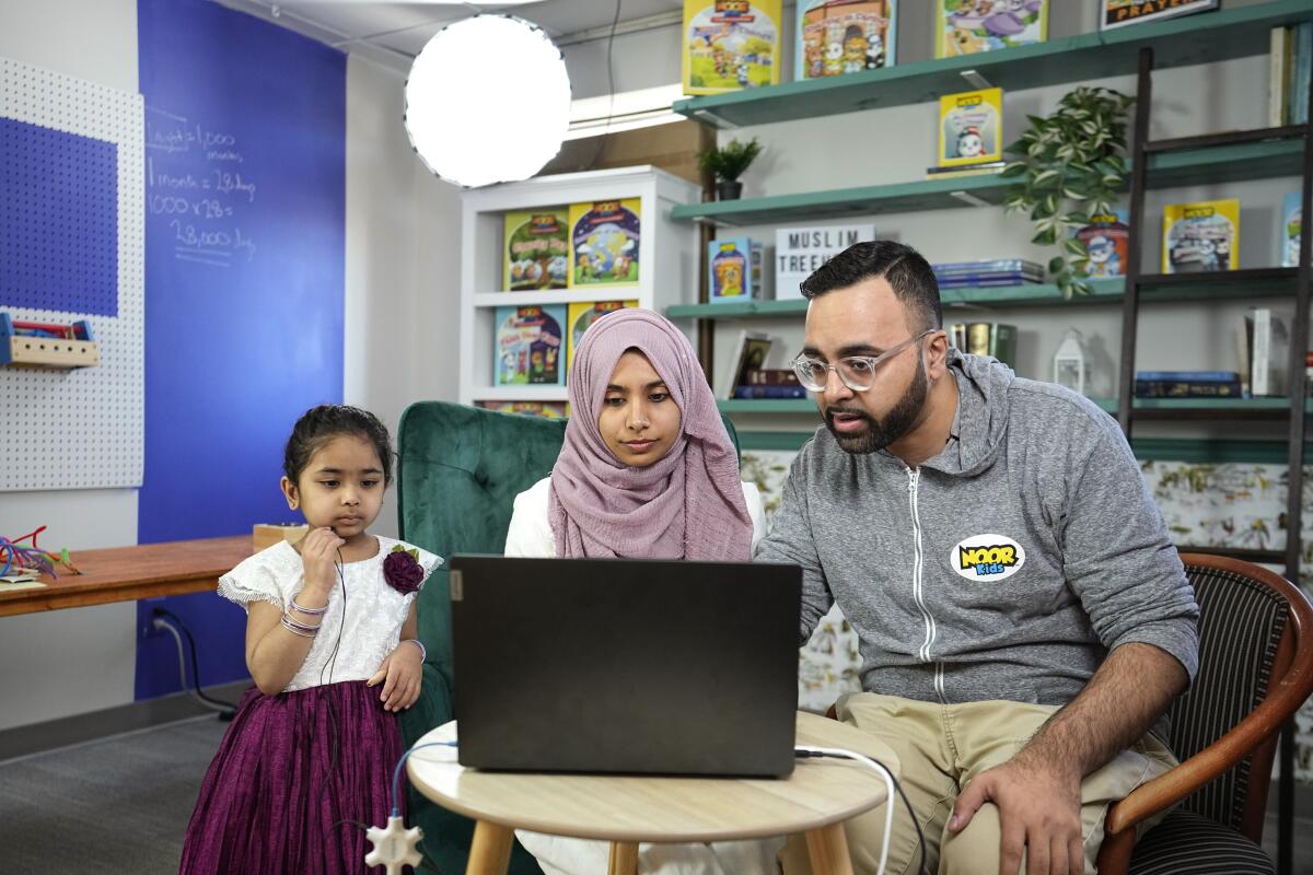 Amin Aaser, a la derecha, su esposa Sana y su hija Kauthar Noor, se preparan para transmitir en vivo