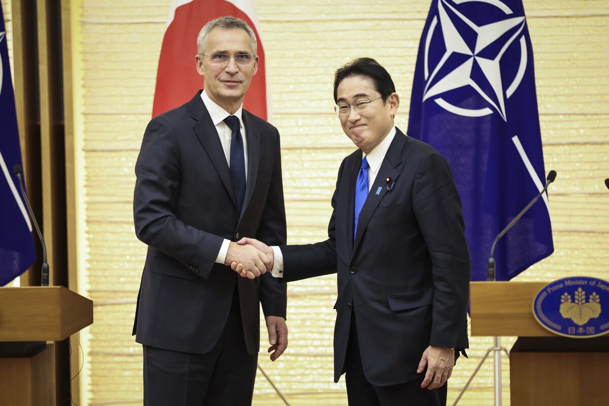 NATO Secretary-General Jens Stoltenberg, left, and Japan's Prime Minister Fumio Kishida shake hands after holding a joint media briefing on Tuesday, Jan. 31, 2023, in Tokyo. (Takashi Aoyama/Pool Photo via AP)