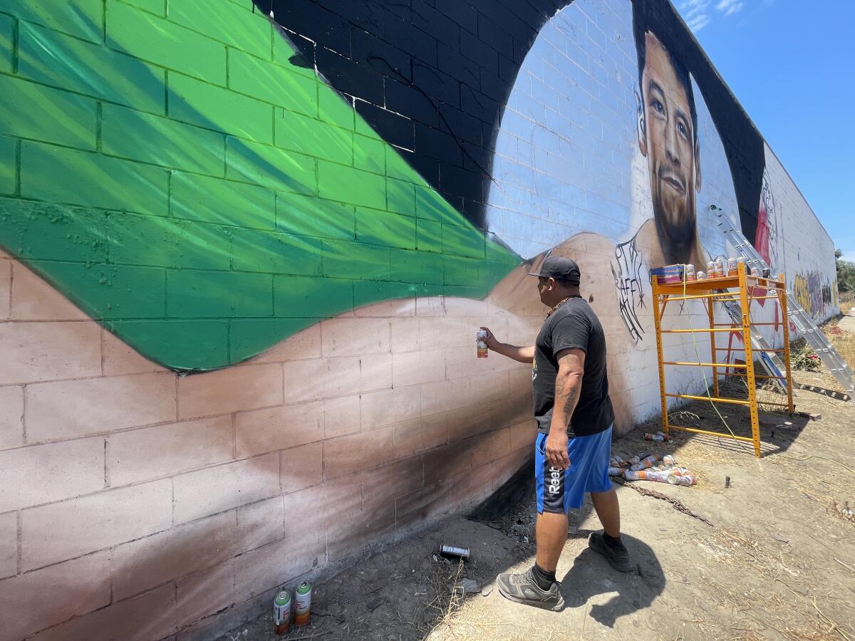 Artist Mode Orozco paints a mural of Ultimate Fighting Championship interim flyweight champion Brandon Moreno in San Ysidro.