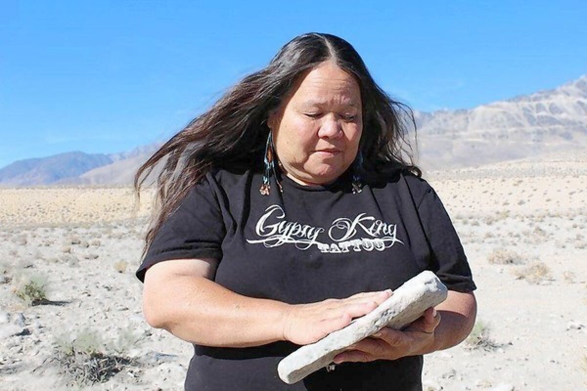 Kathy Jefferson Bancroft, tribal historic preservation officer for the Lone Pine Paiute-Shoshone Reservation, examinines a possible grinding stone she unearthed near a burial site.