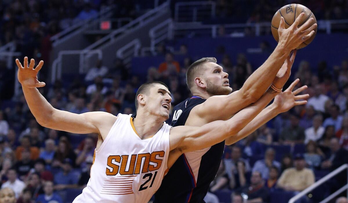 Clippers' Cole Aldrich, right, grabs a rebound in front of Phoenix Suns' Alex Len during the first half of on Wednesday.