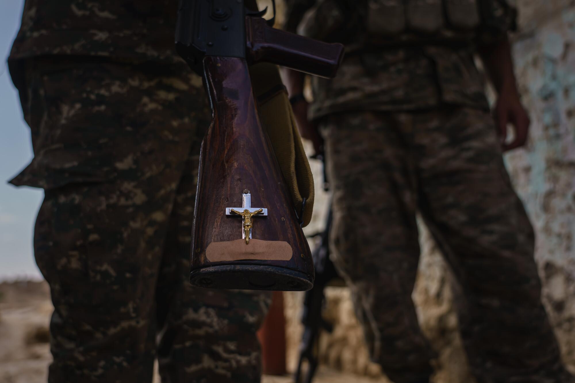 Soldiers show off religious decorations on their rifles.