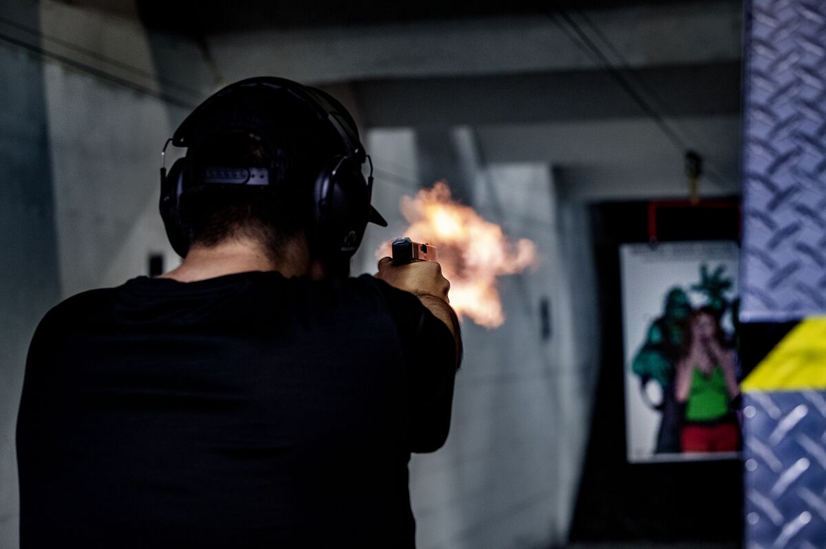 A person holding a gun shoots at a target. 