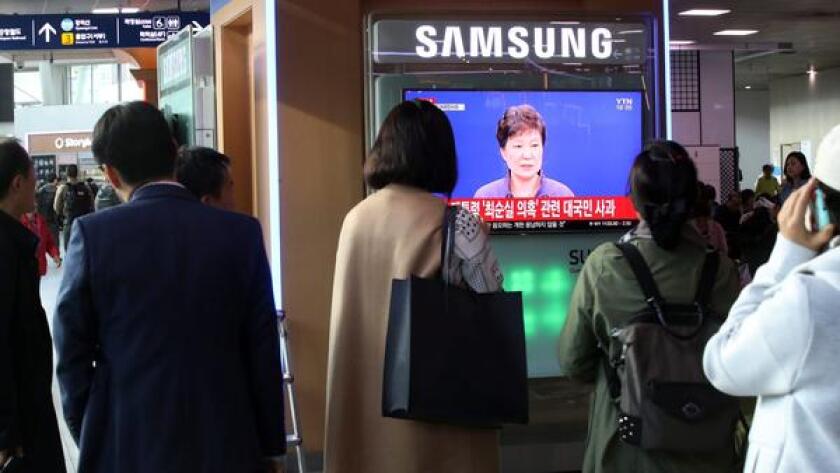People watch South Korean President Park Geun-hye's live-aired public apology over the leak of confidential documents, including presidential speech drafts, Oct. 25 in Seoul.