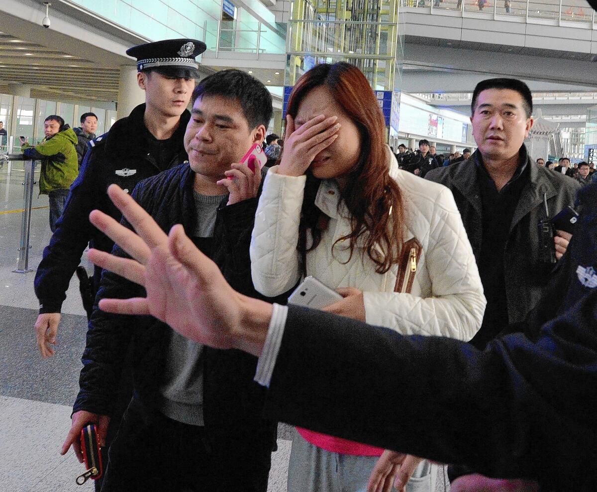 A woman at Beijing Capital International Airport reacts to the news that a Malaysia Airlines flight with 239 people aboard was missing.