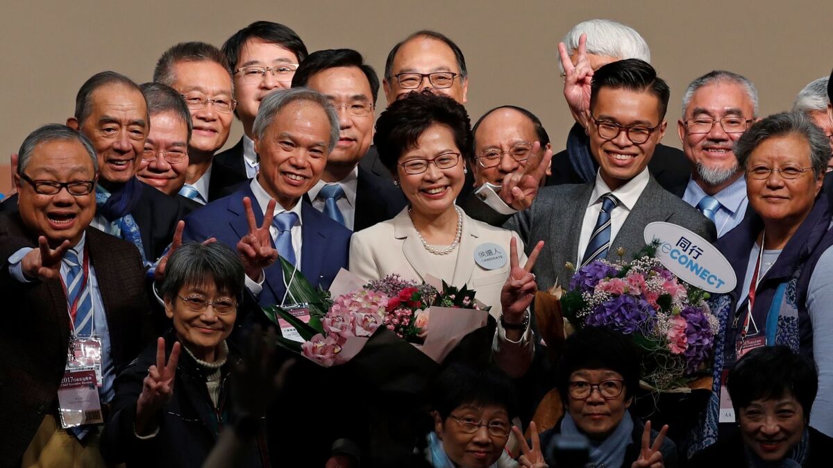 Hong Kong's former No. 2 official, Carrie Lam, center, acknowledges supporters after winning the vote for chief executive on March 26, 2017. (Kin Cheung / AP)