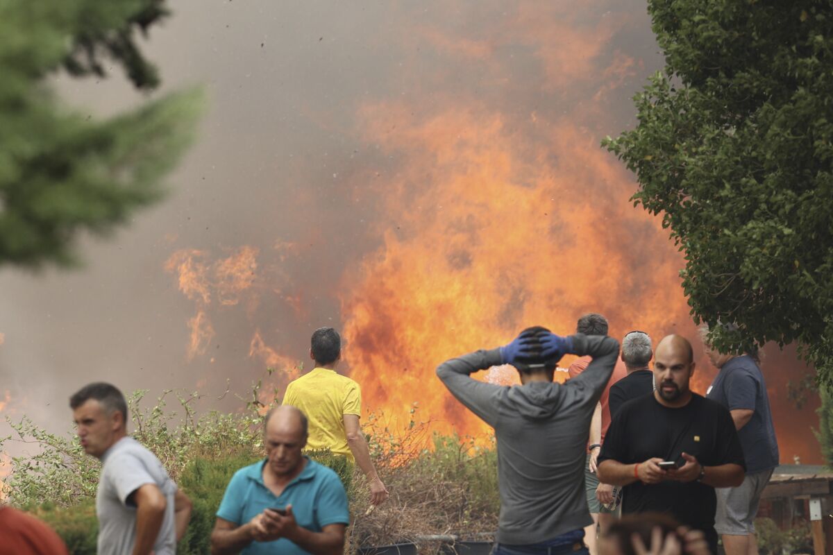 Vecinos se alejan de un incendio forestal en Añón de Moncayo, en Zaragoza, España, el sábado 13 de agosto de 2022. (Fabian Simon/Europa Press vía AP)