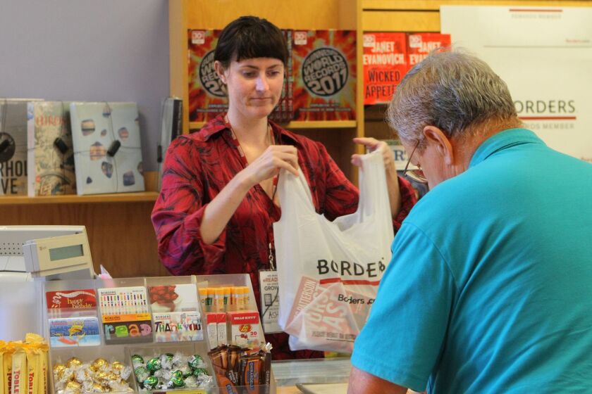 A Borders employee helps a customer at the Mission Valley store prior to Friday's bankruptcy. The book chain will close all its 399 stores nationwide, which employed 10,700.
