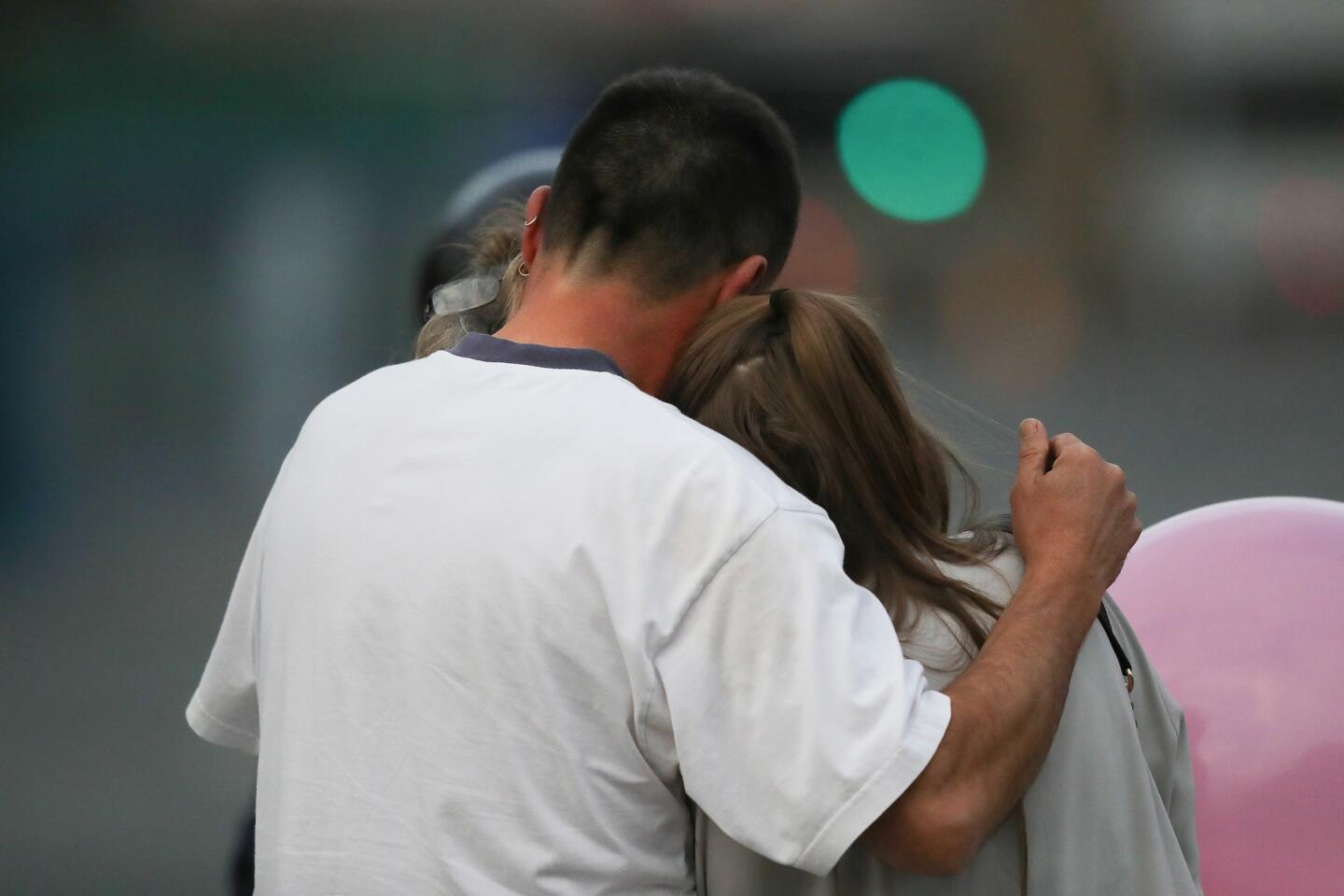 A man embraces a woman and a teenager on Tuesday as he collects them from the Park Inn Hotel, where they were given refuge after the explosion at Manchester Arena.