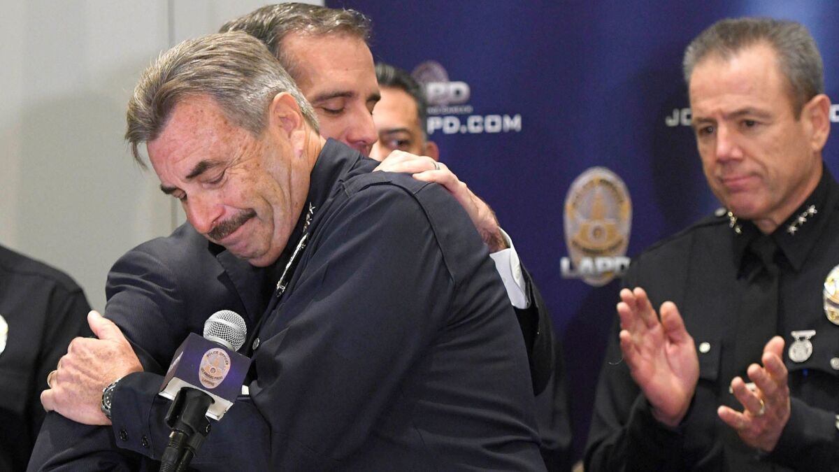 Charlie Beck and L.A. Mayor Eric Garcetti embrace after the LAPD chief announced his retirement, effective June 27, at a news conference on Jan. 19.