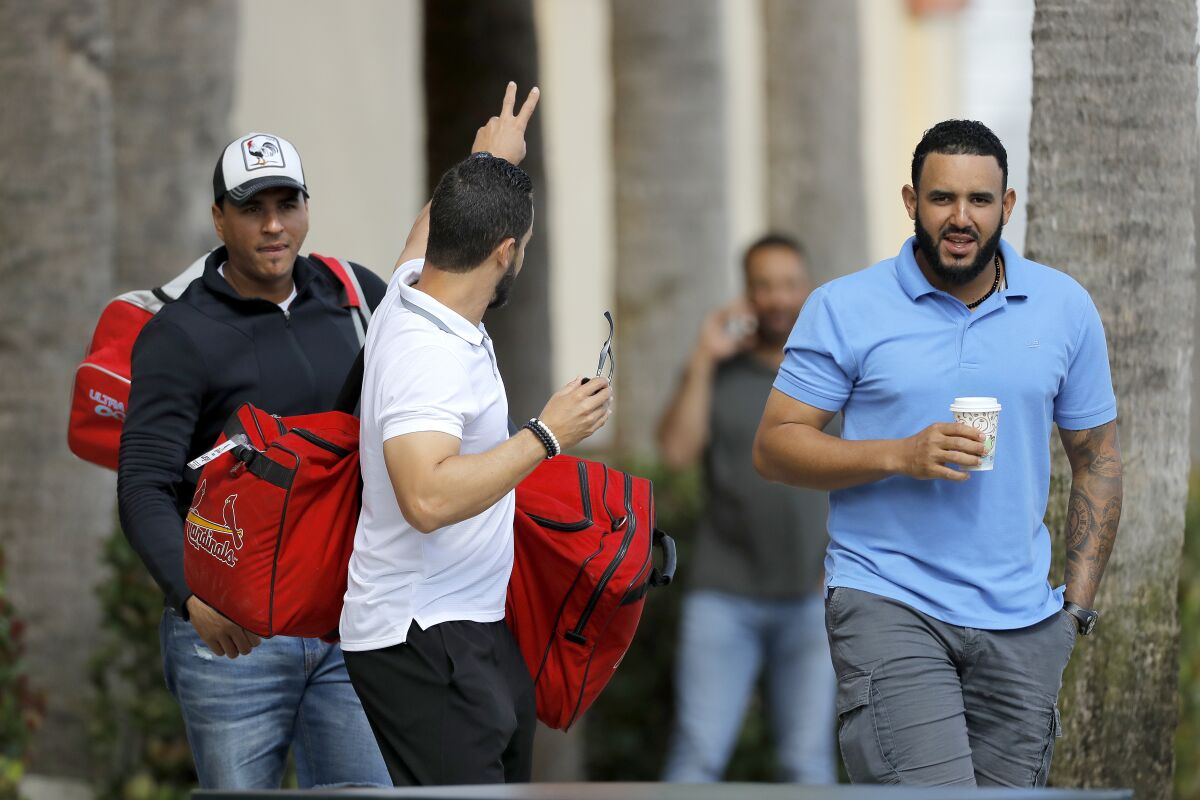 St. Louis Cardinals minor league players leave the team's spring training baseball facility in Jupiter, Fla., on March 13.